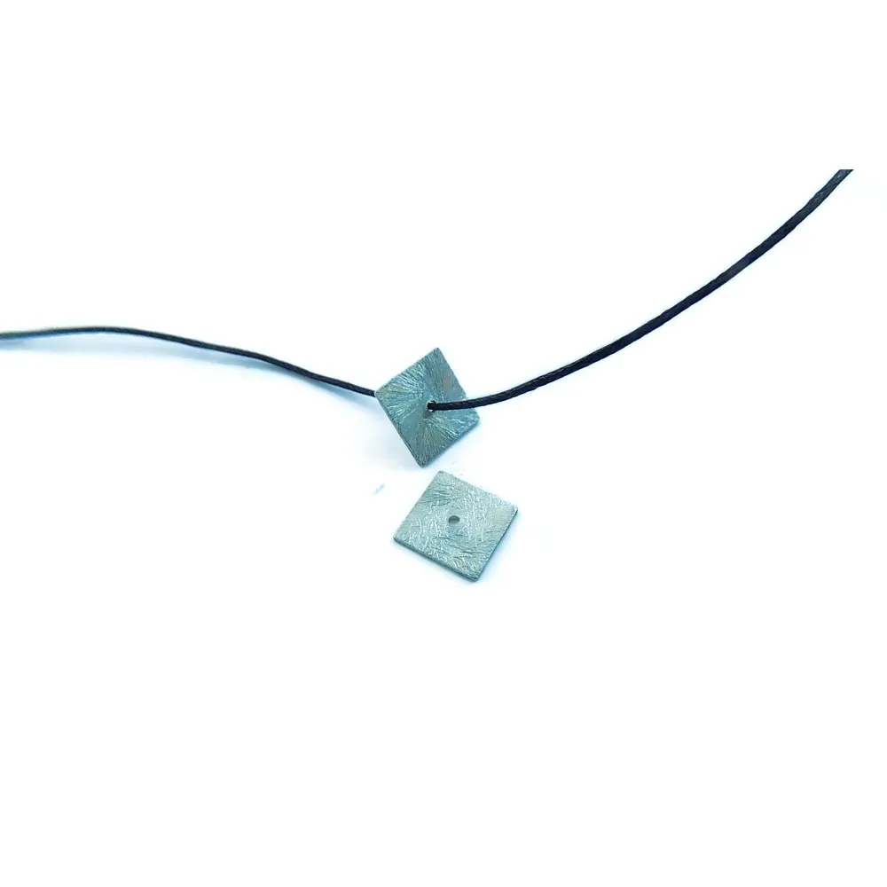 un quadrato 12x12 mm. in argento 925 rodiato graffiato con foro